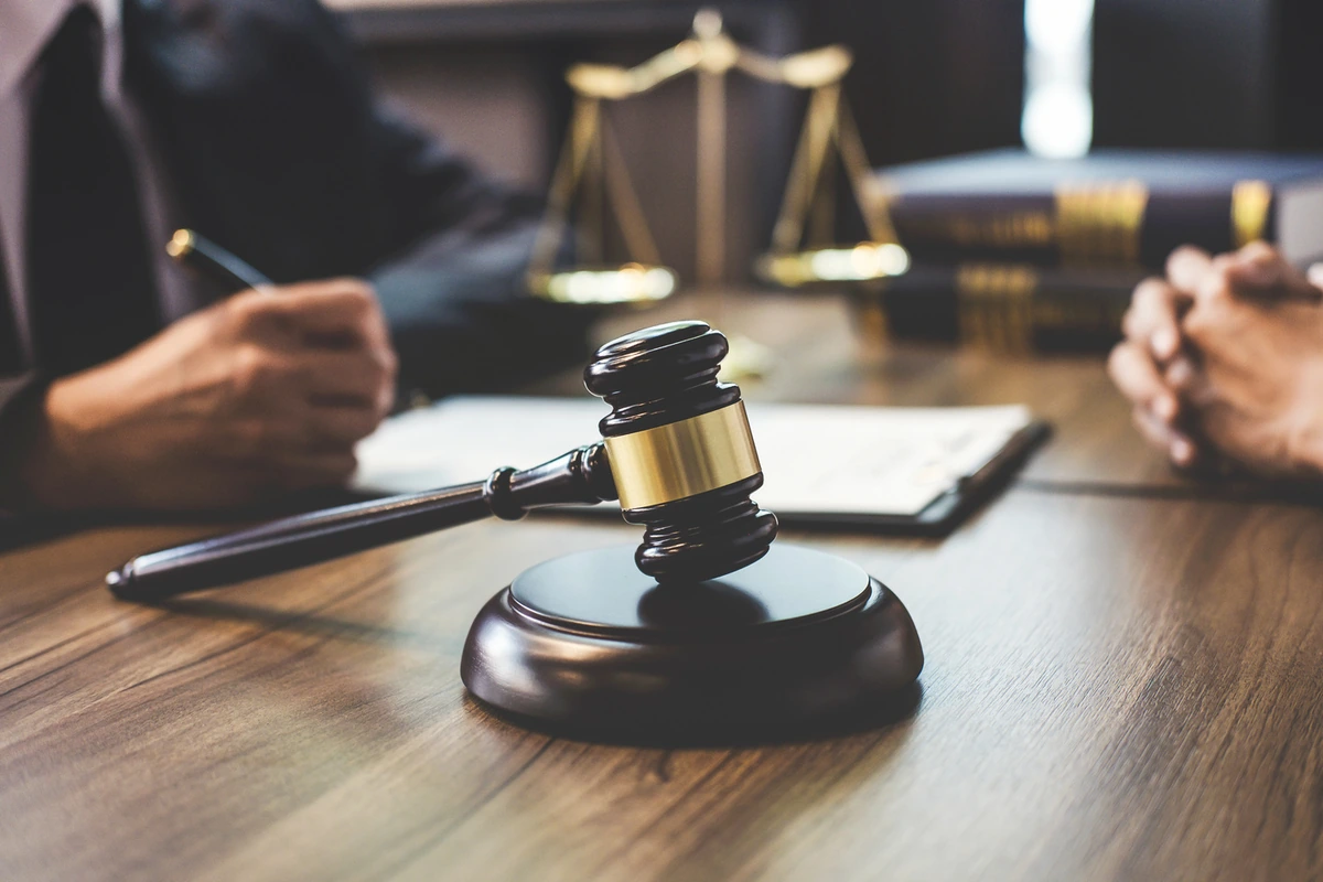 Gavel and scales of justice on a desk; U.S. trademark applications are filed through a licensed attorney