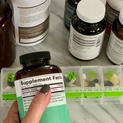 woman-s-hand-holding-a-bottle-of-vitamins-checking-2024-12-03-15-32-34-utc (1) woman-s-hand-holding-a-bottle-of-vitamins-checking-2024-12-03-15-32-34-utc (1)